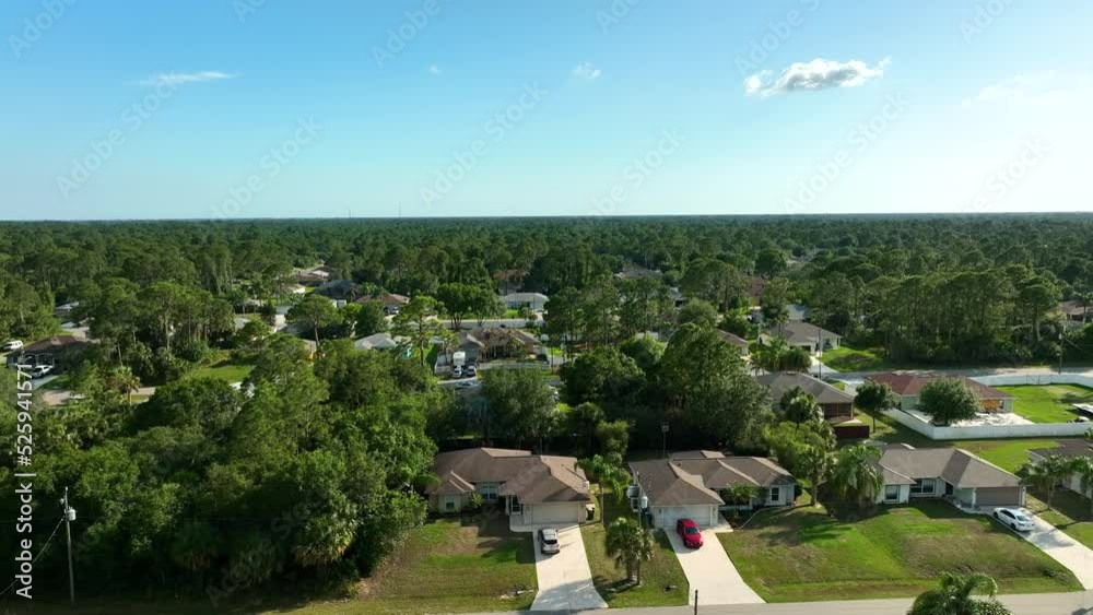 Aerial view of suburban landscape with private homes between green palm trees in Florida quiet residential area Aerial view of suburban landscape with private homes between green palm trees in Florida quiet residential area