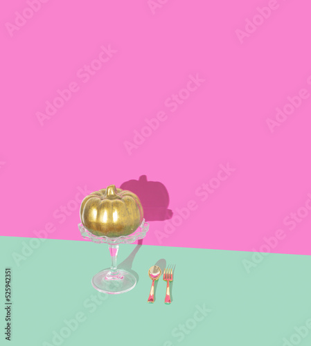 Golden pumpkin on cake holder with golden spoon and fork. Aesthetic Thanksgiving or Halloween composition in a minimalist style, trendy pastel colors.