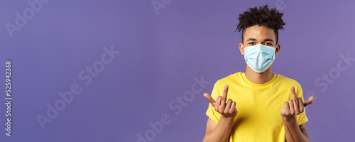 Medicine, covid19, coronavirus and people concept. Fuck you virus, unbothered, smart young hipster guy in medical mask show middle fingers and smile with eyes, staying protected indoors