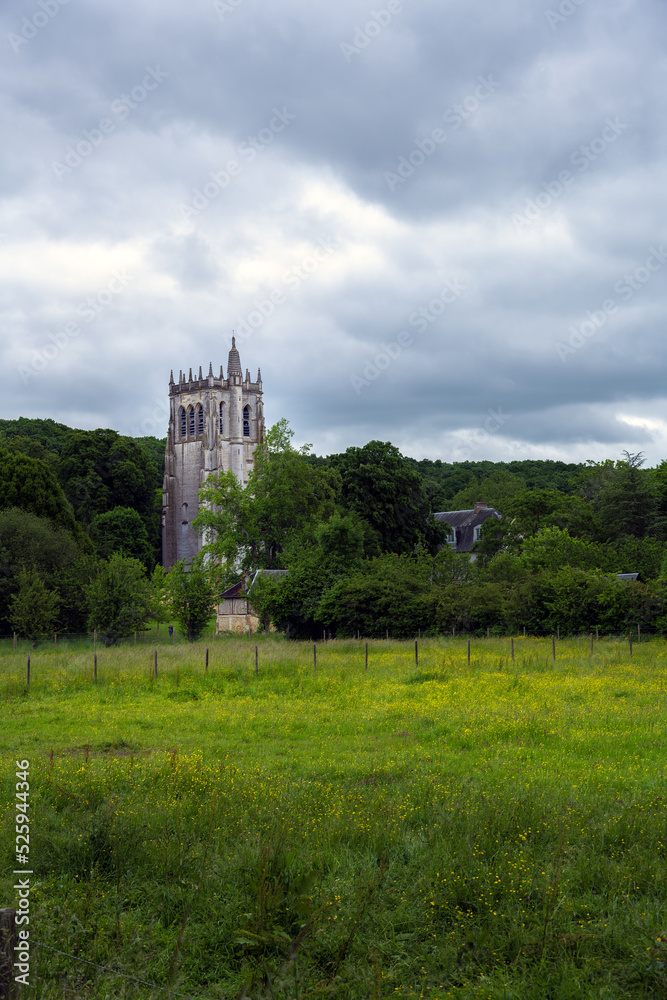 Fototapeta premium St Nicolas tower in the Notre-Dame du Bec Benedictine abbey on a cloudy spring afternoon, Le Bec-Hellouin, Normandy, France