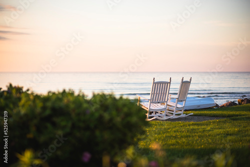 Empty Outdoor Rocking Chairs at coastal summer sunrise photo