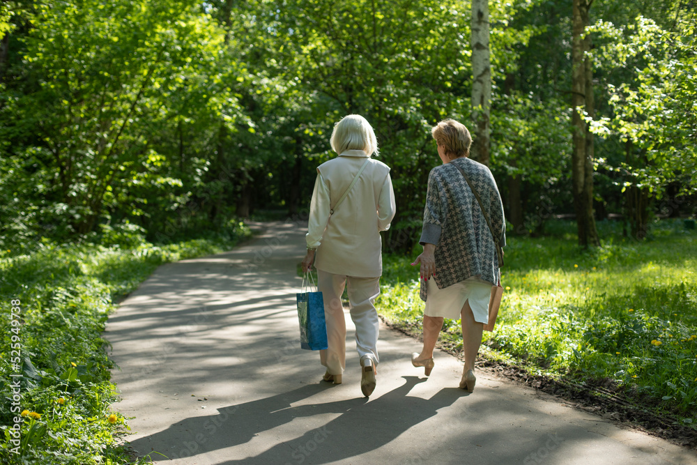 Women walk through park. Walk through park in summer. Women walk through park. Walk through park in summer.