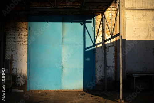 Gate to large garage. Blue gate to warehouse. Industrial zone.