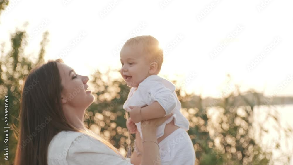 Young longhaired mommy walking and playing with her baby at sunset in the vineyards Young longhaired mommy walking and playing with her baby at sunset in the vineyards