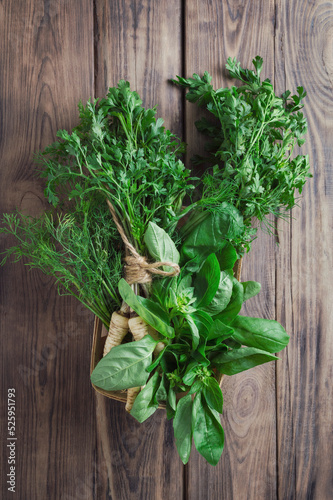 Fresh celery, parsley, basil and dill on a wooden background. Top view. Flat lay. Greens for salads and vitamin drinks.