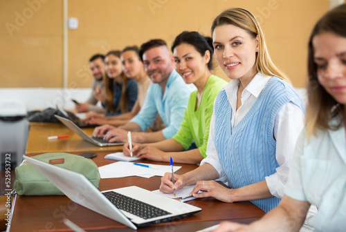 Small group of students attentively listening to lecture in university classroom