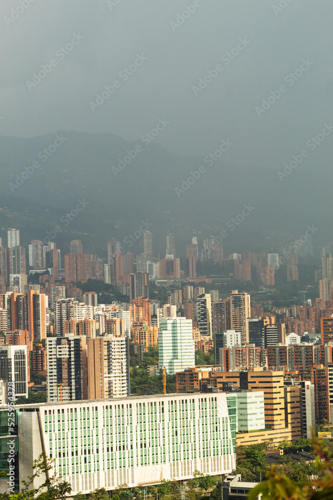 Vertical image of Medellin, Colombia during a sunset with a bit of fog in the mountains