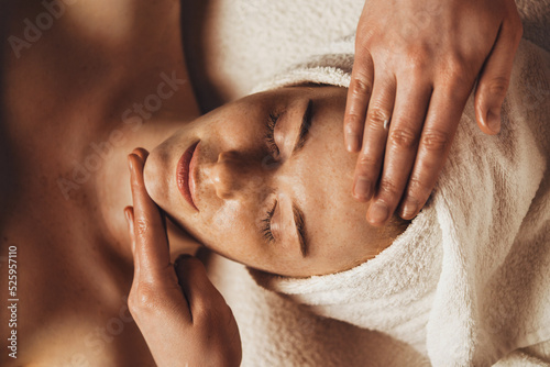Close-up view of a freckled caucasian woman having facial treatment and massage skin therapy at spa salon. Health care, beauty treatment. Skin treatment