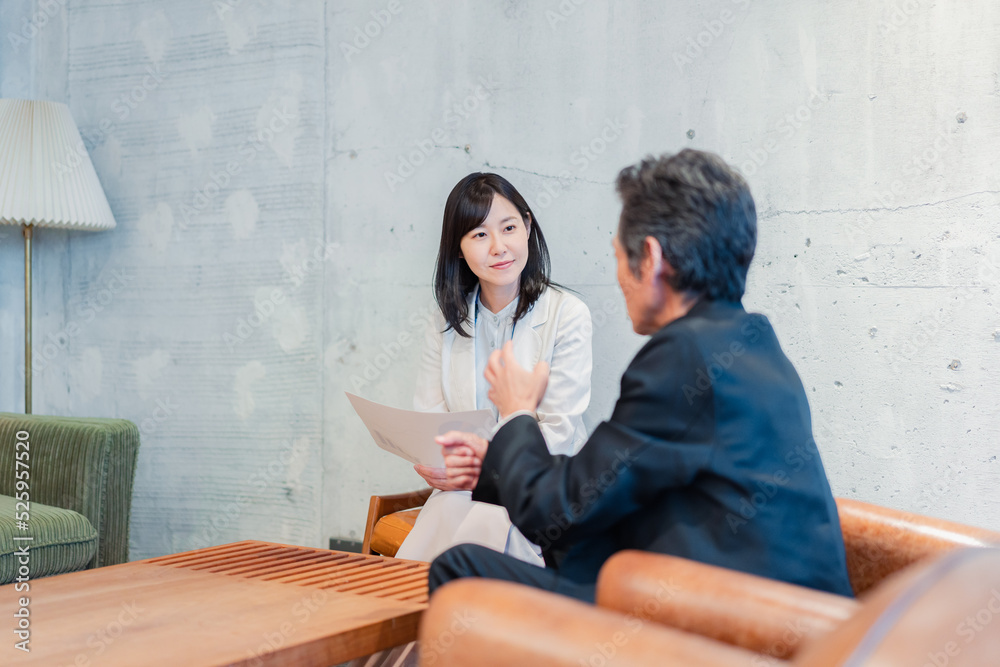 ビジネスマンに保険の勧誘をする営業の女性 ビジネスマンに保険の勧誘をする営業の女性