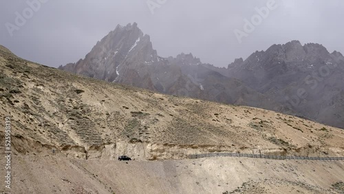 A Man Inside His Car Slowly Driving Approaching Srinagar Leh Ladakh HIghway On A Rainy Day. - Rear, Slow Motion photo