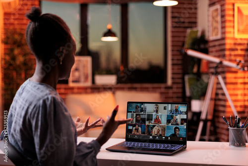 Corporate worker talking with remote team on business meeting using laptop, back view. Company colleagues brainstorming on teleconference, freelancing and telework concept