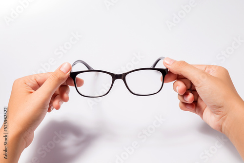 Woman holding the black eye glasses spectacles with shiny black frame isolated on white