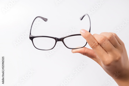 Woman holding the black eye glasses spectacles with shiny black frame isolated on white