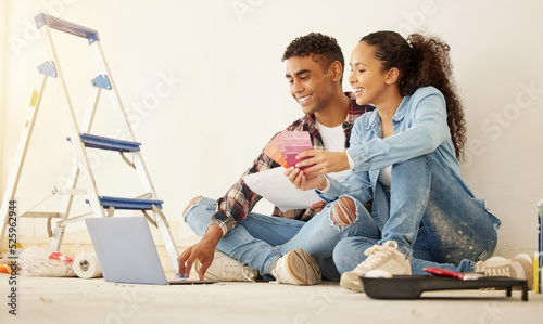фотографія Interior design planning home renovation with laptop, paint colour choices and happy couple time together on internet