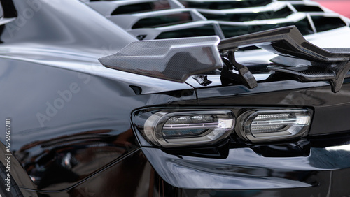 Luxury black sports car fragment, rear aerodynamics carbon spoiler and rear lights © Евгений Бордовский