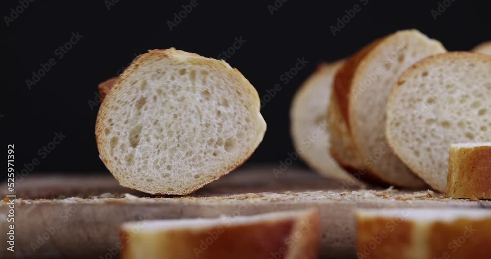 a wheat baguette cut into pieces swings , a fresh baguette made of wheat flour during the preparation of sandwiches a wheat baguette cut into pieces swings , a fresh baguette made of wheat flour during the preparation of sandwiches