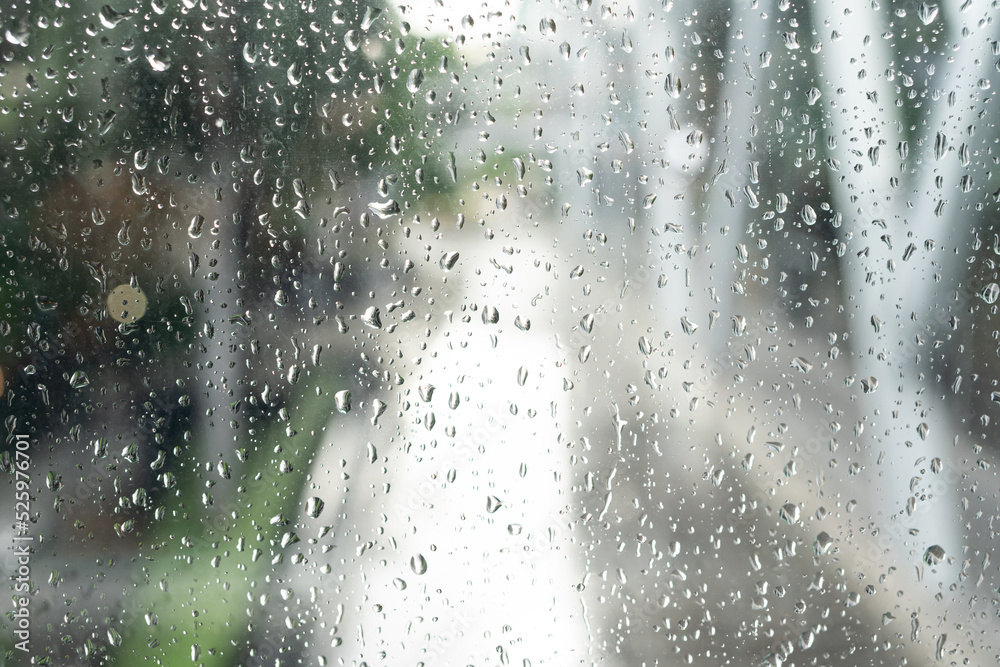 Morning city,view through the window on rainy day. Water droplets on the glass on a rainy day. rain drops during raining in rainy day outside window glass with blurred background.