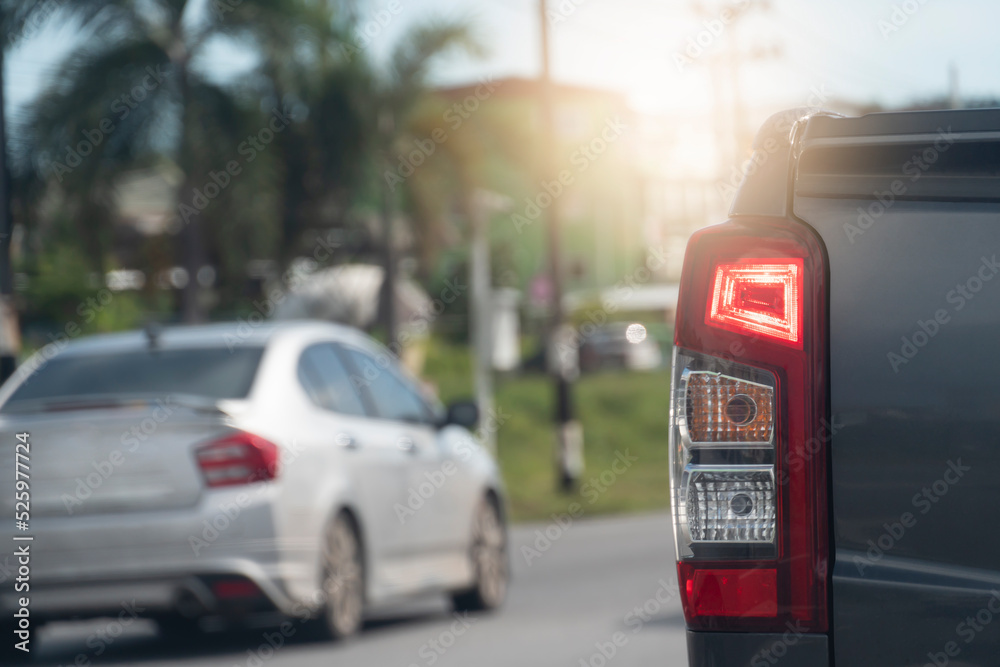 Rear side of pick up car gray color stops on the road with turn on brake light. background and blurred of other cars stop in the city at days. Rear side of pick up car gray color stops on the road with turn on brake light. background and blurred of other cars stop in the city at days.
