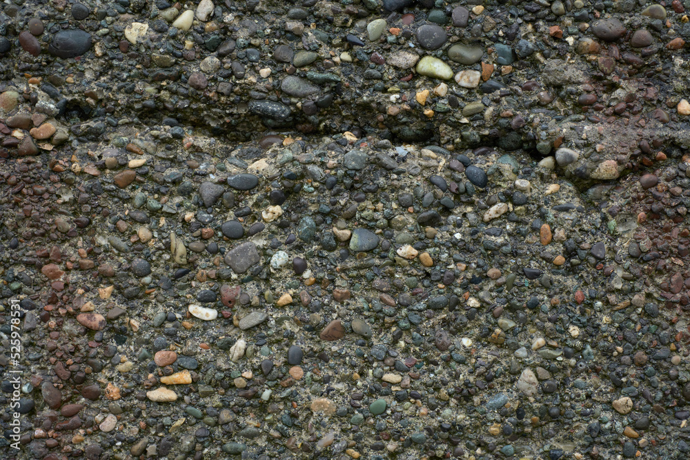 Gray pebbles and cement wall texture, beach sandstone background.