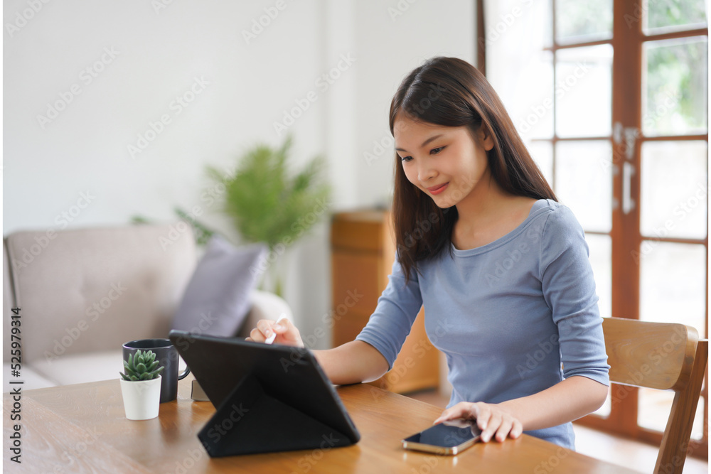 Work from home concept, Business women reads financial data on tablet to working in living room Work from home concept, Business women reads financial data on tablet to working in living room