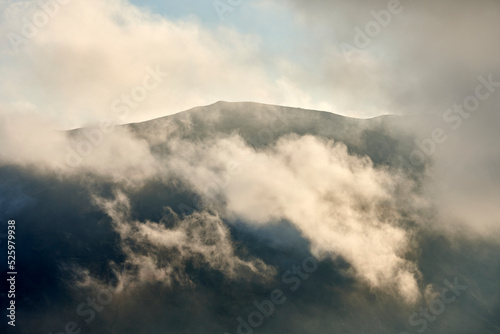 White clouds floating over volcanic mountainous terrain