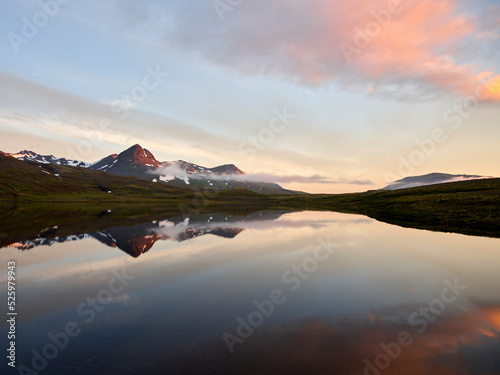 Mountain lake reflecting clouds in morning © Cavan
