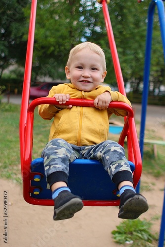Smiling boy on swings at playground