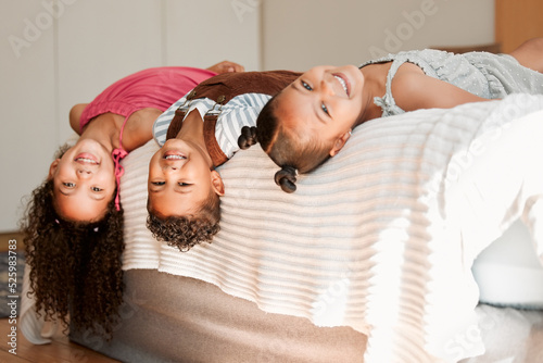 Fun, playful and silly kids lying on a bed with cute hairstyle and smiling portrait. Little siblings relaxing, playing indoors showing growth, child development and childhood innocence photo