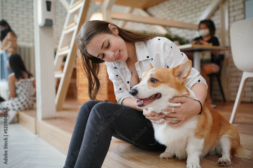 Young woman with her dog at modern house on nature light.