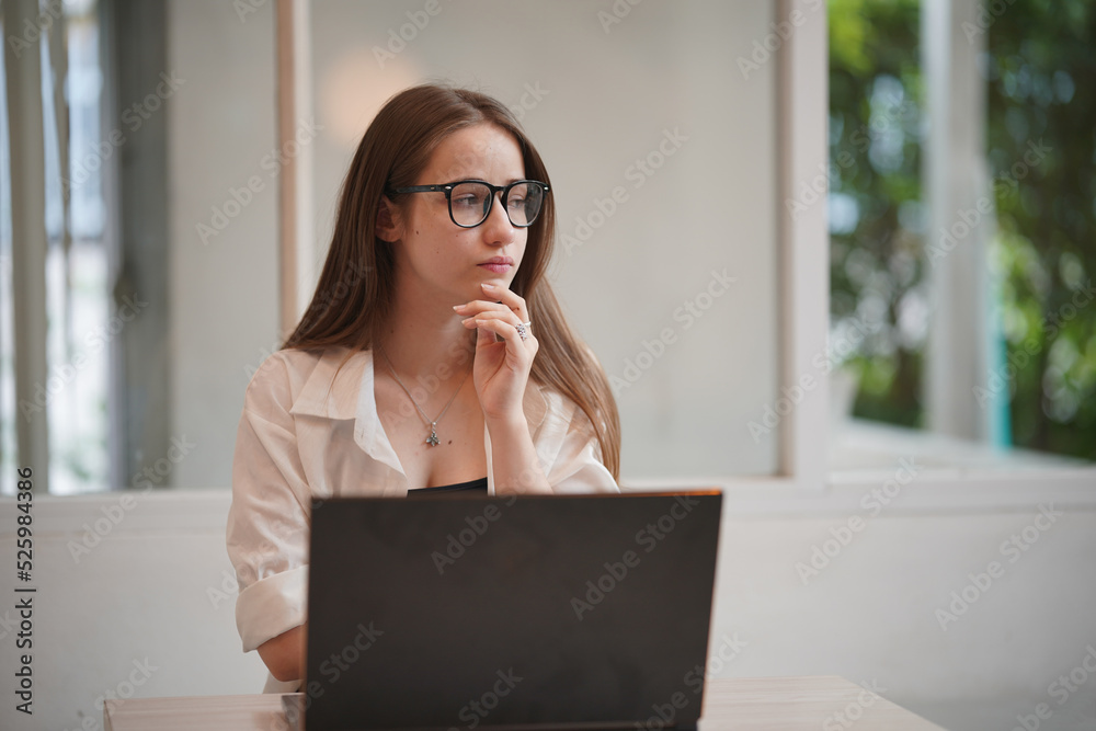 Technology and people concept, young woman using laptop and internet technology and sitting on the desk with laptop computer.