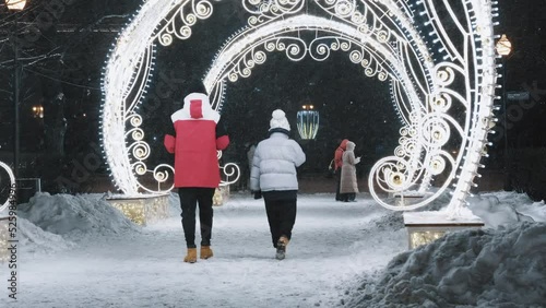 Moscow, Russia, December 2021. Romantic walk. A couple of lovers are strolling through the city center, enjoying Christmas decorations on a snowy winter evening.