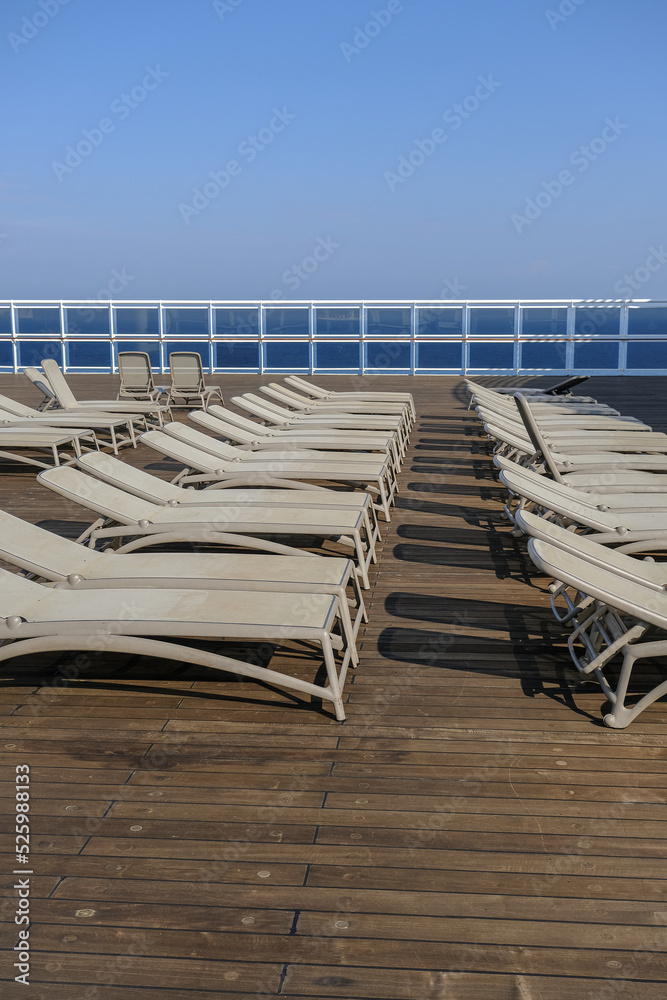 Fototapeta premium View from open outdoor deck of legendary luxury ocean liner cruise ship on passage during Transatlantic Crossing from Southampton to New York with deck chairs, railing and superstructure