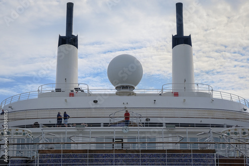 View from open outdoor deck of legendary luxury ocean liner cruise ship on passage during Transatlantic Crossing from Southampton to New York with deck chairs, railing and superstructure photo