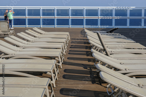 View from open outdoor deck of legendary luxury ocean liner cruise ship on passage during Transatlantic Crossing from Southampton to New York with deck chairs, railing and superstructure © Tamme