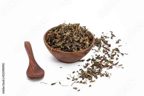 Dry mehndi leaves or henna mehendi or lawsonia inermis in wooden bowl on white background