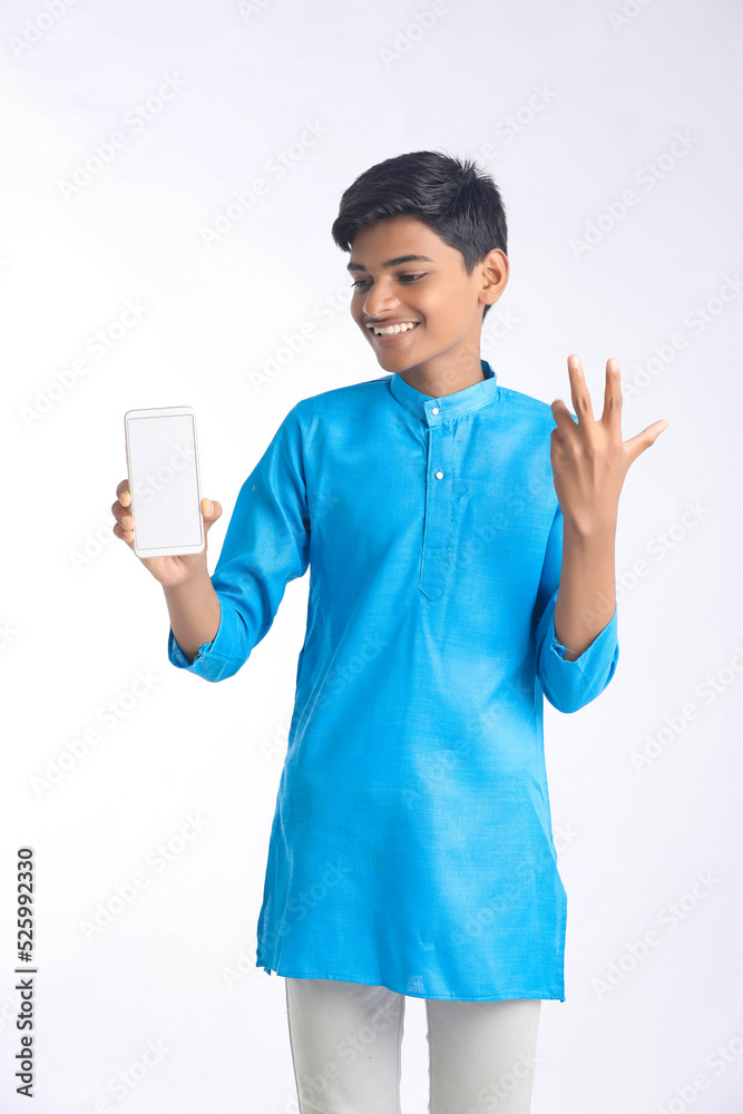 Indian boy in traditional wear and showing smartphone on white background. Indian boy in traditional wear and showing smartphone on white background.