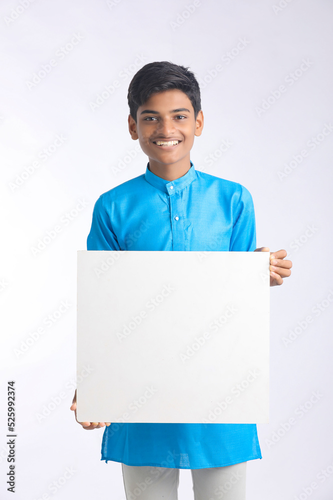 Indian boy showing white board with copy space on white background. Indian boy showing white board with copy space on white background.