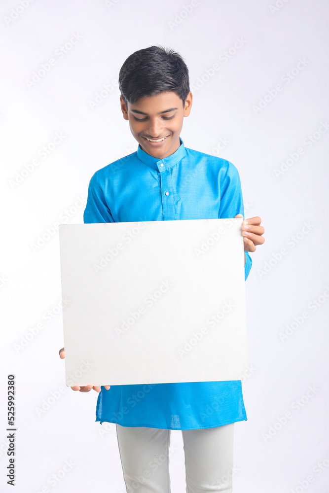 Indian boy showing white board with copy space on white background. Indian boy showing white board with copy space on white background.