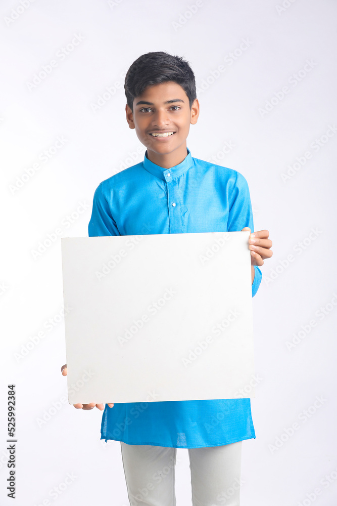 Indian boy showing white board with copy space on white background. Indian boy showing white board with copy space on white background.
