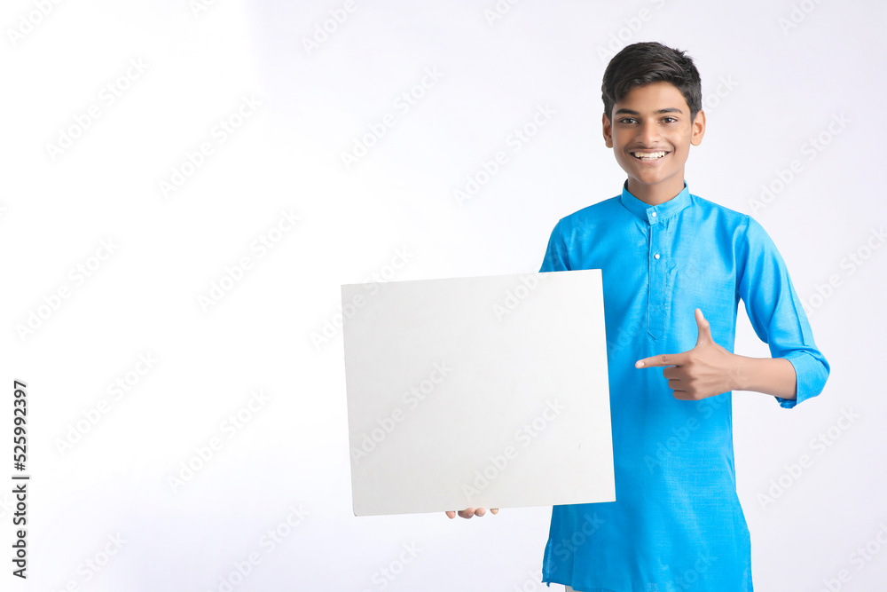 Indian boy showing white board with copy space on white background. Indian boy showing white board with copy space on white background.