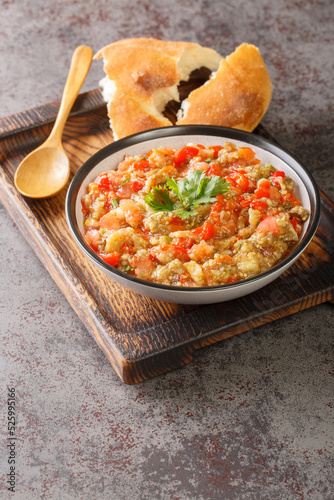 Eggplant caviar with tomatoes, garlic and roasted bell pepper closeup in the bowl on the table. Vertical photo