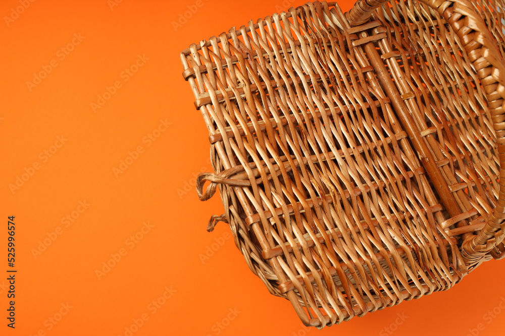 Wicker basket for picnic on orange background Wicker basket for picnic on orange background