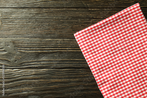 Red and white checkered tablecloth on wooden background
