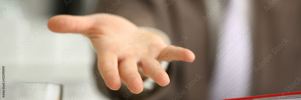 Man in suit extends open hand forward closeup Man in suit extends open hand forward closeup