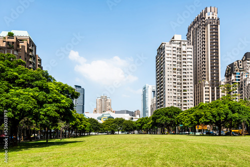 Low-angle view of park green space and modern buildings on both sides in downtown Taichung, Taiwan. here is near the National Taichung Theater. © BINGJHEN