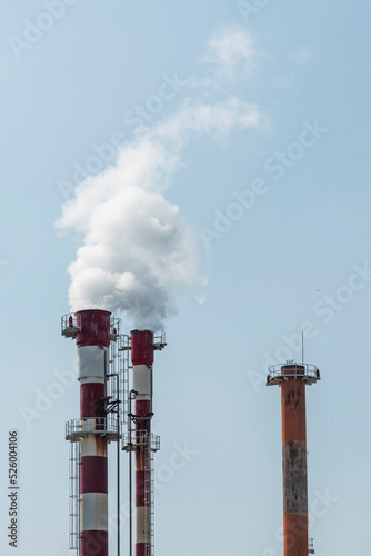 Air pollution by smoke coming out of two factory chimneys.