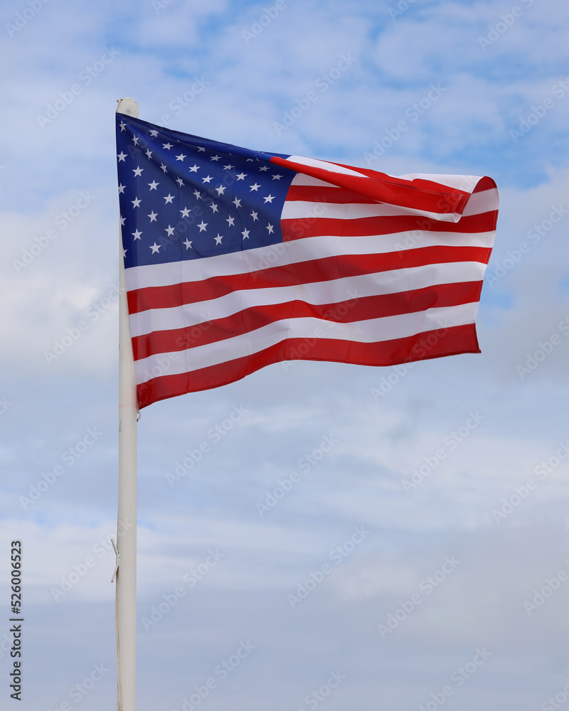 Waving flag of United States of America on blue sky