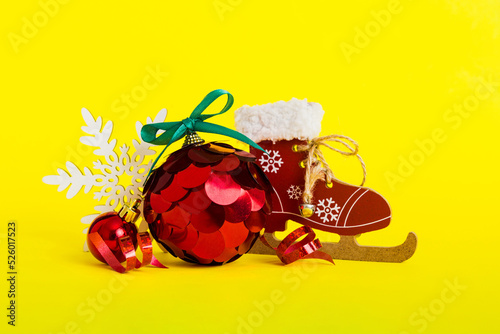 Christmas ball with skates on colored background. decoration bauble with ribbon bow with copy space