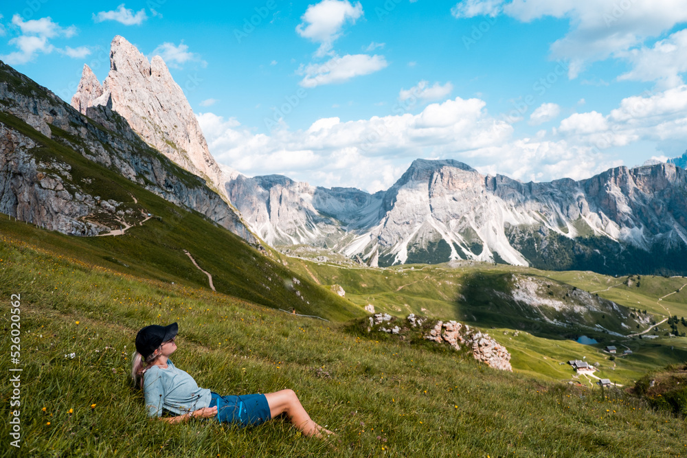 Woman rest on fields around mountains after a hike