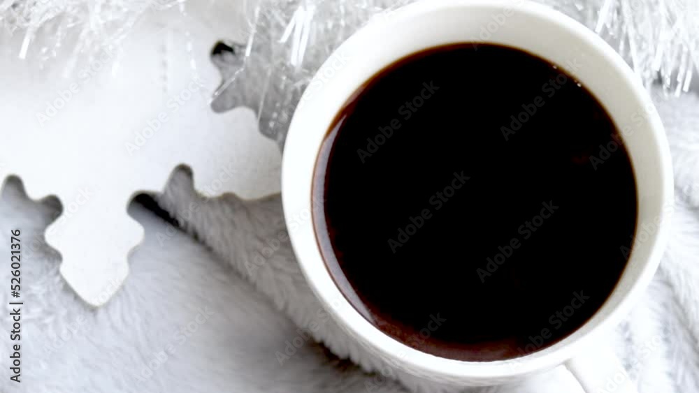 cup of hot black espresso coffee on christmas background white garland and wooden manual diy painted snowflake shape.gray blanket.coffee steam slow motion hd video.cozy home